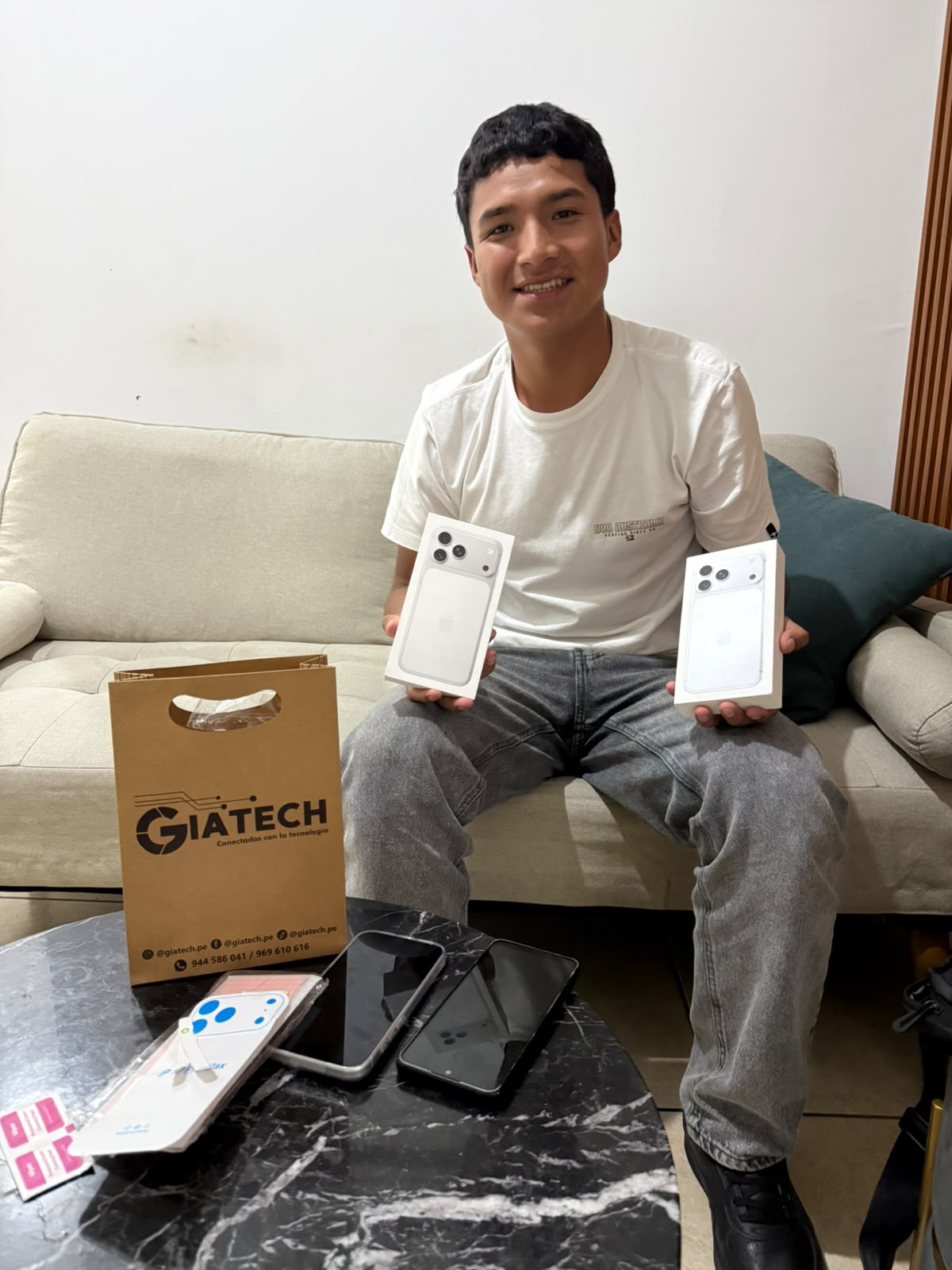 Cliente con dos cajas de iPhone y una bolsa de GIATECH.