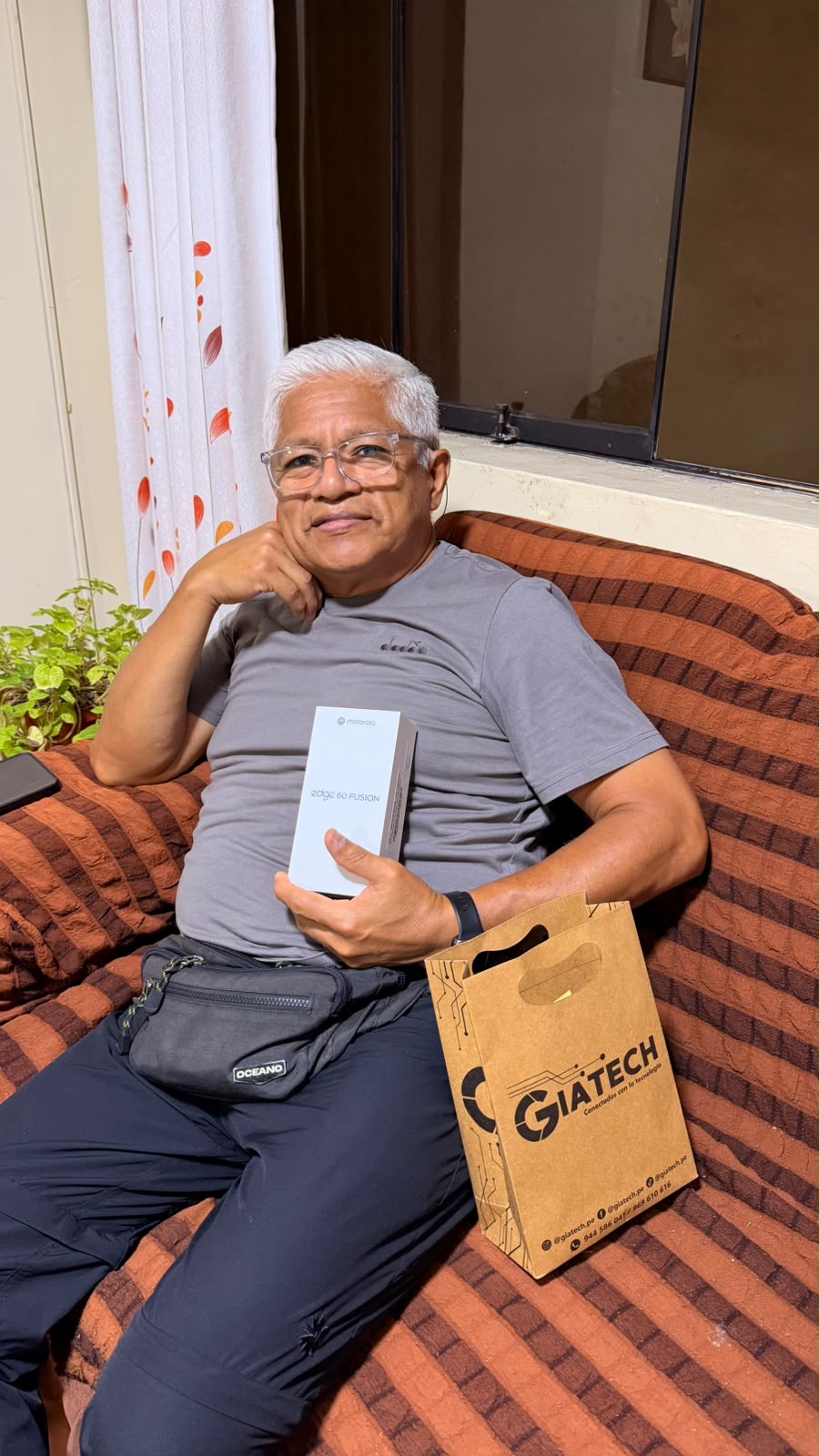 Cliente con la caja de su Motorola y una bolsa de GIATECH.