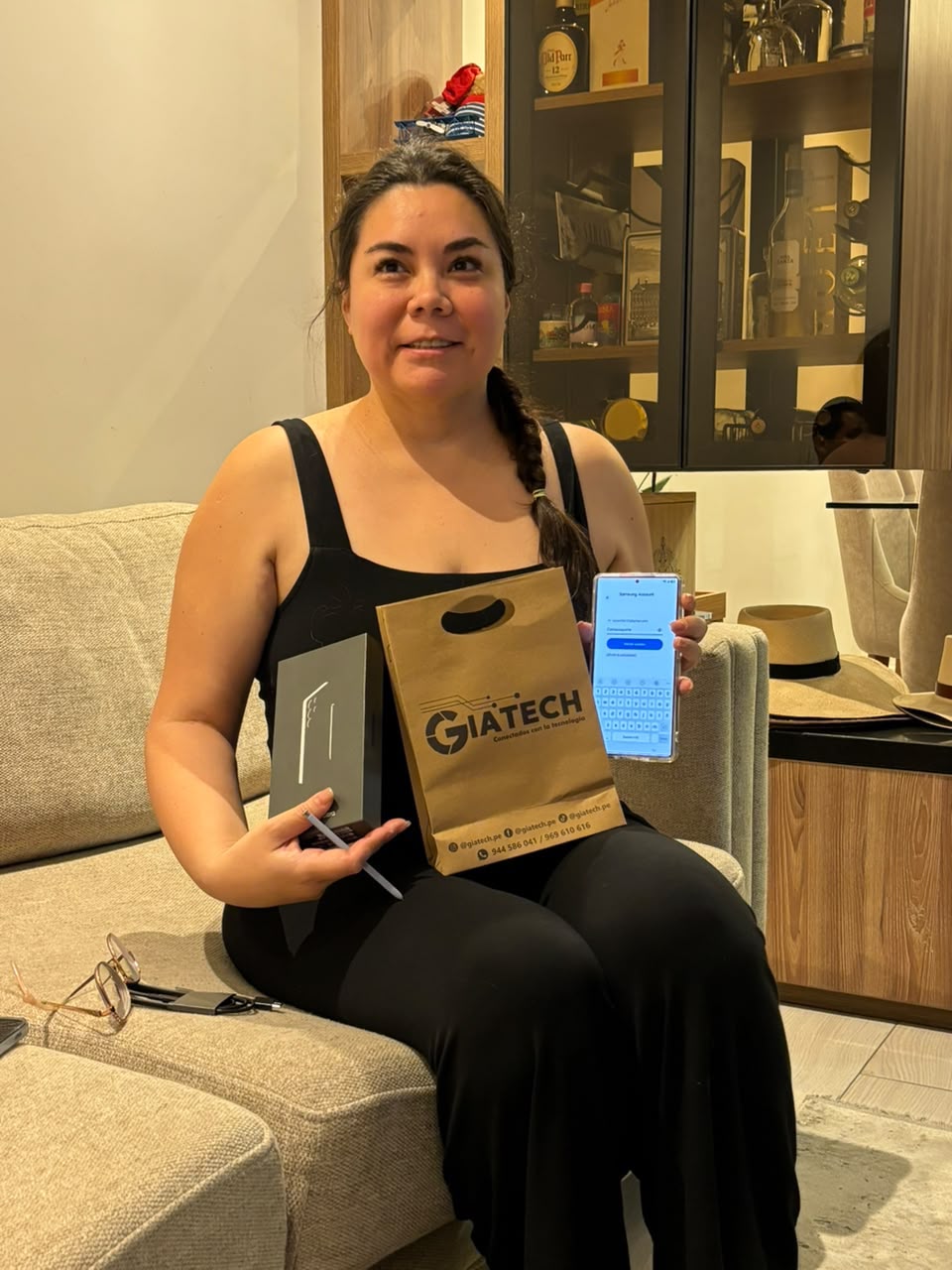Clienta con su celular, caja y bolsa de GIATECH.